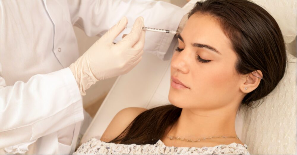 Provider in white gloves gently evaluating a woman’s face during a Botox treatment