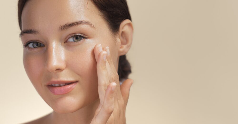 Woman touching her glowing skin after a DiamondGlow facial treatment