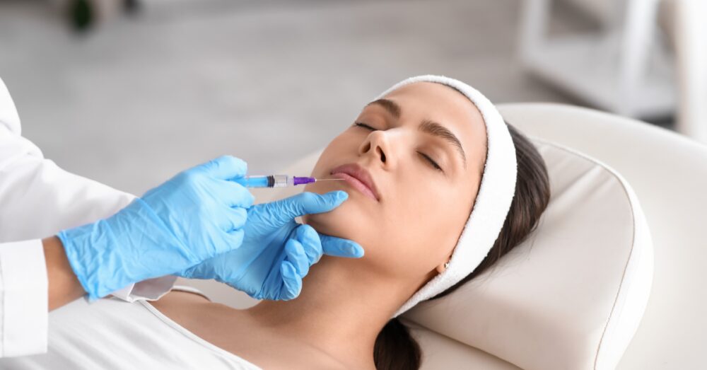 Provider in gloves administering a lip filler or lip flip injection