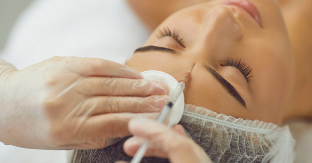 Woman with eyes closed receiving an injectable treatment